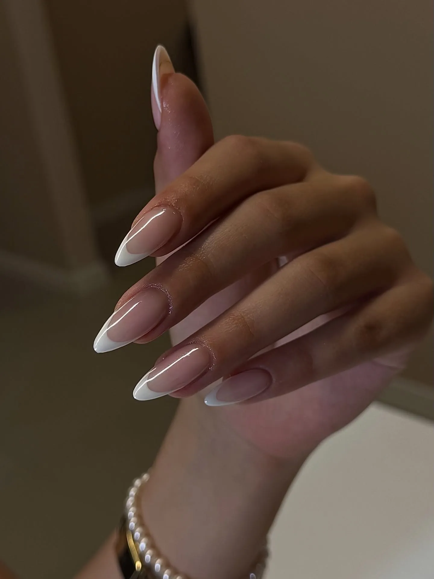 Nude almond nails with slim white French tips