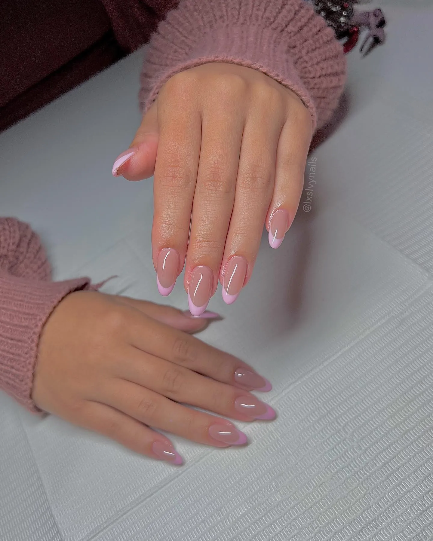 Pale pink almond nails with slim white French edges