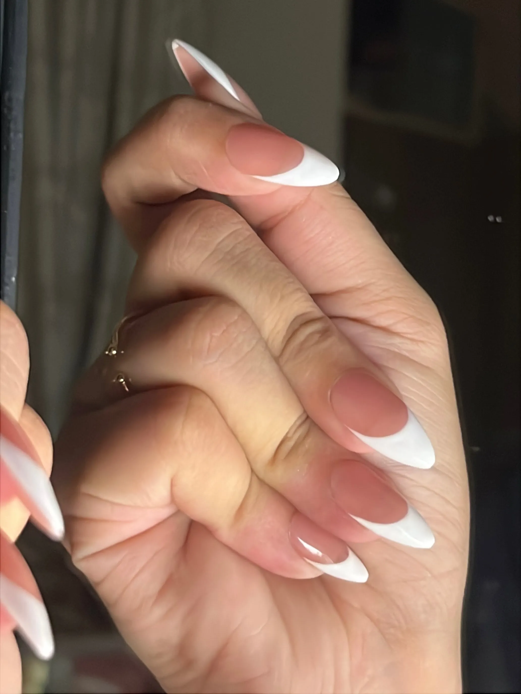 Nude pink almond nails with bright curved white French tips