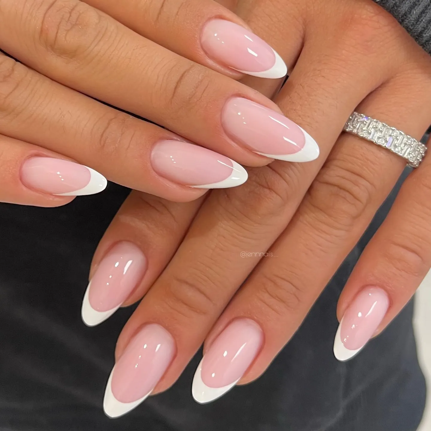 Glossy pink almond nails with deep curved white tips