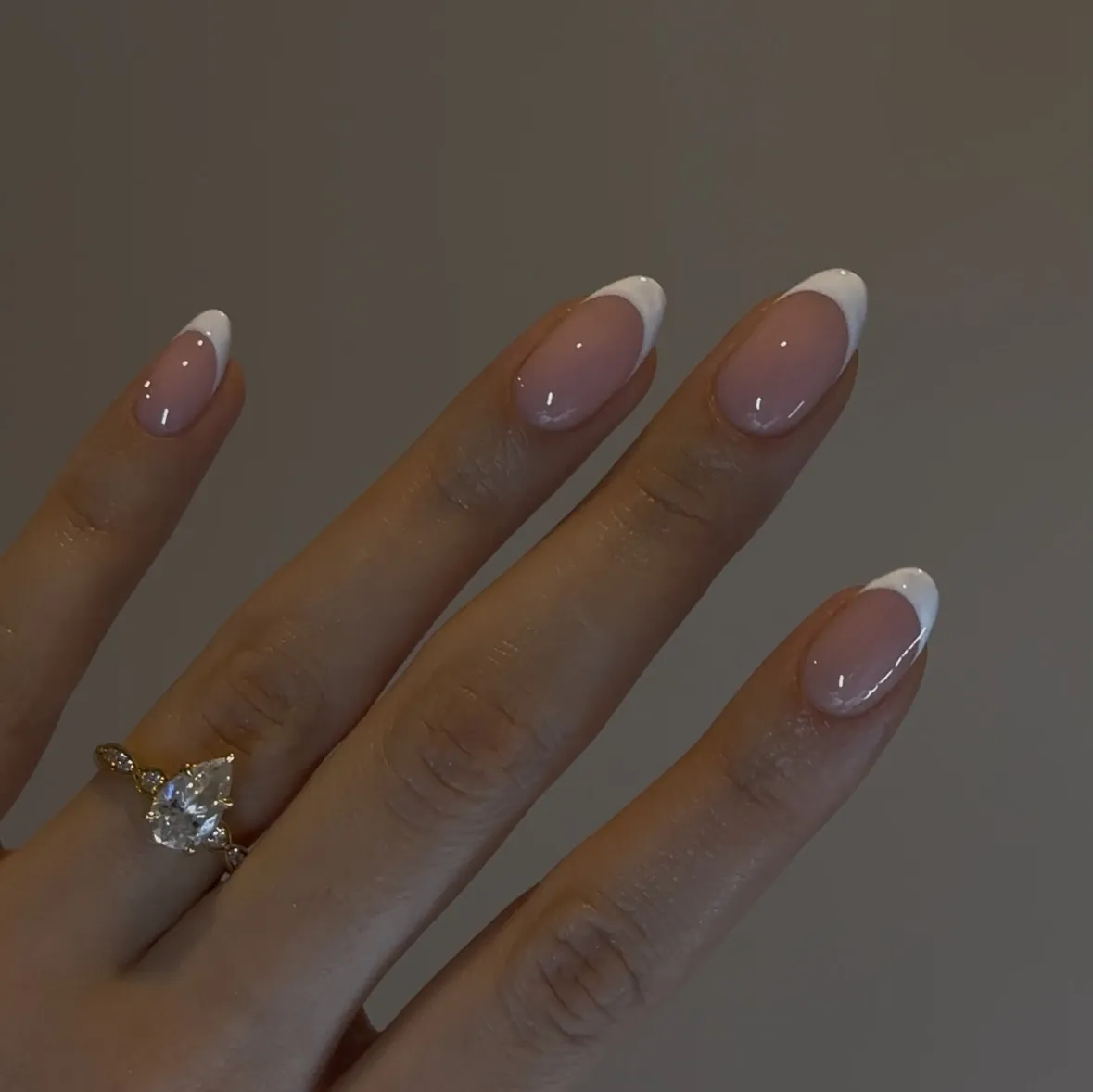 Sheer nude almond nails with delicate white tip borders