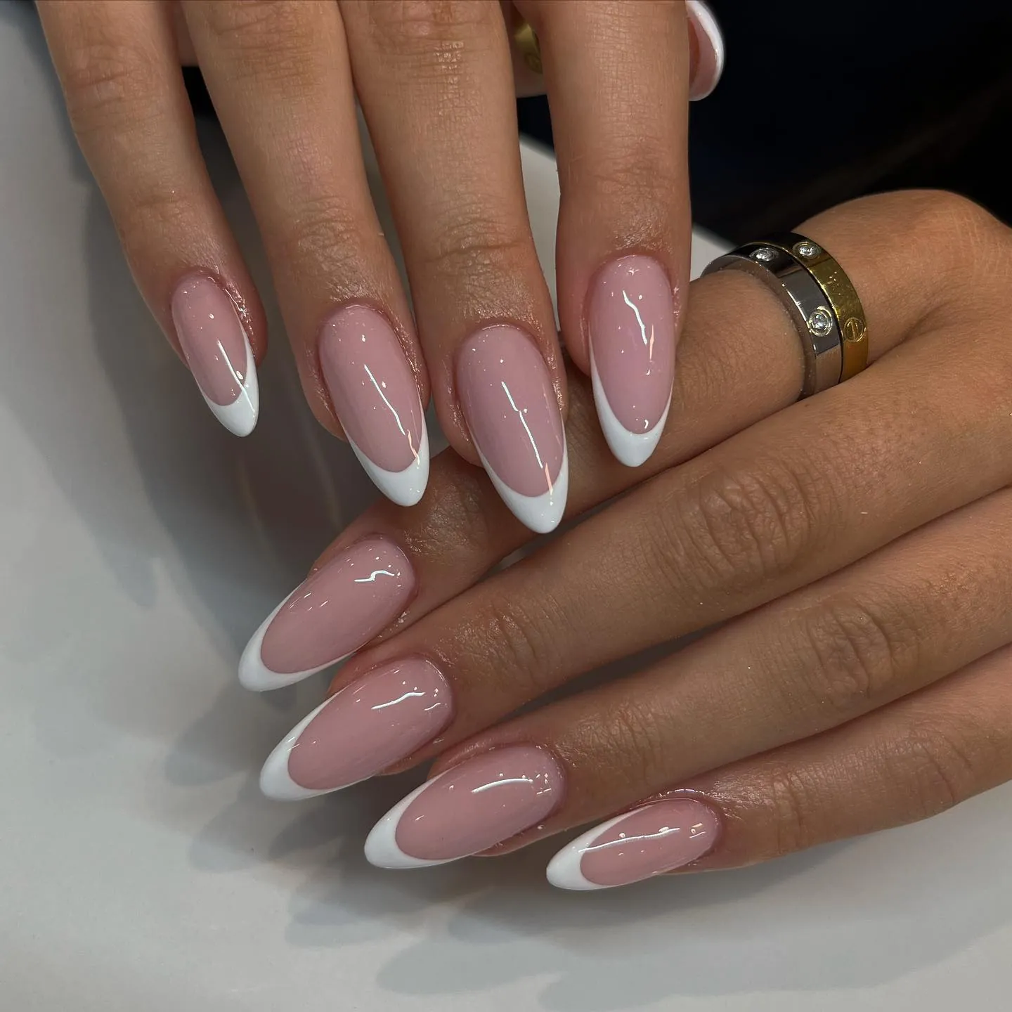 Nude pink almond nails with clean curved white tips