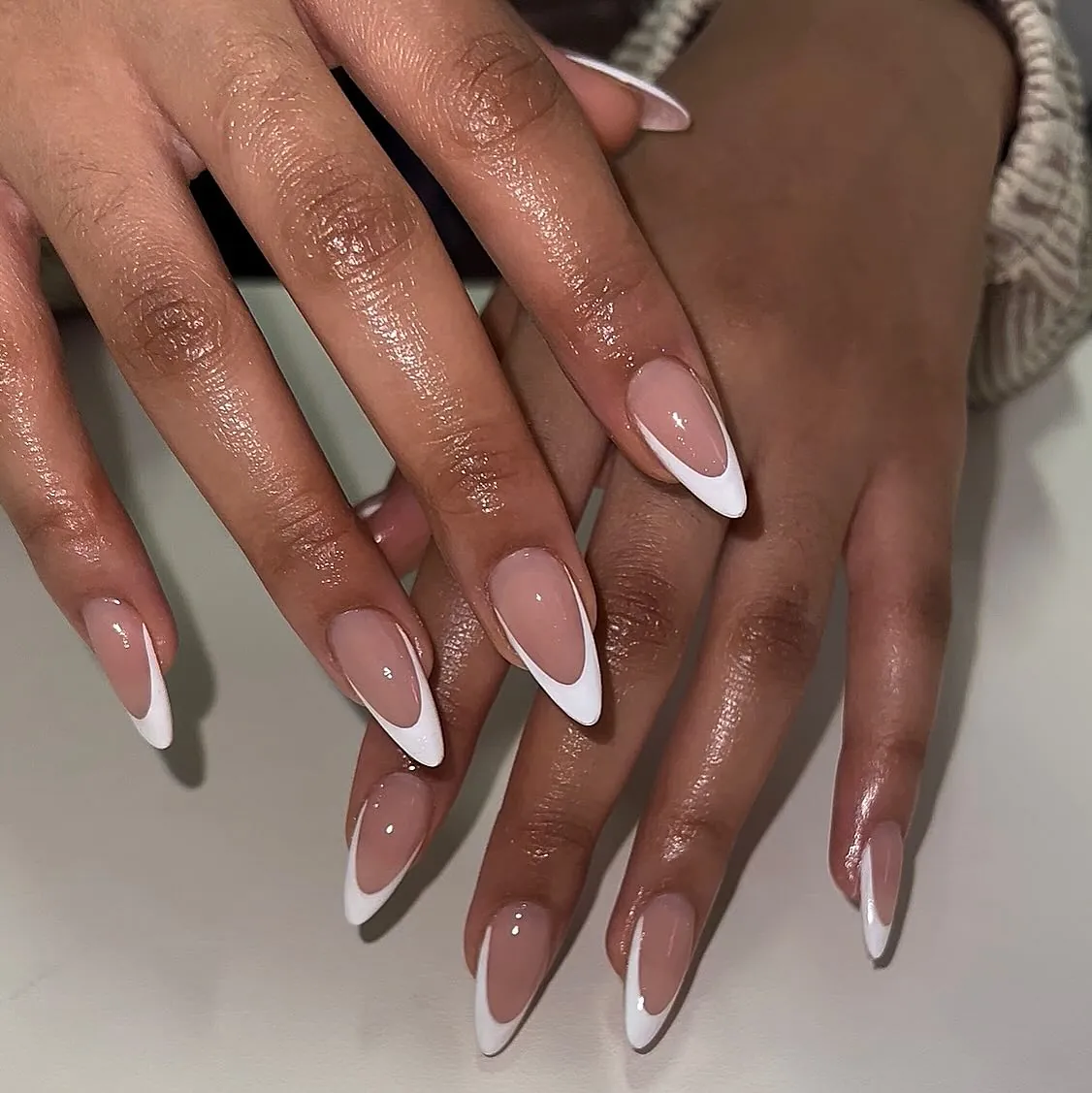Long nude almond nails with deep white French curves