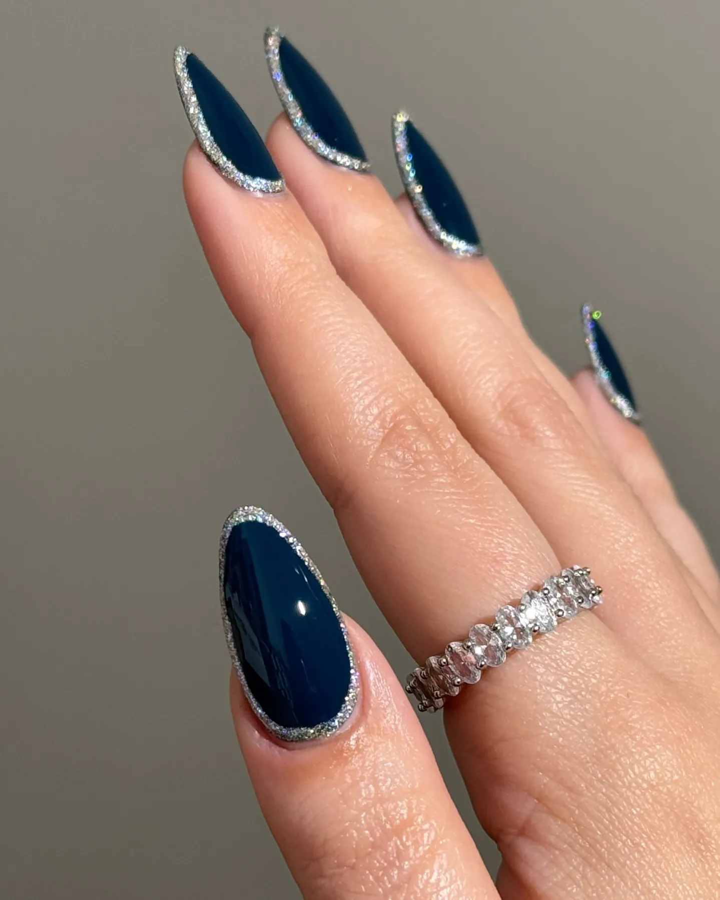 Long pointed navy nails with sparkling silver borders around each nail