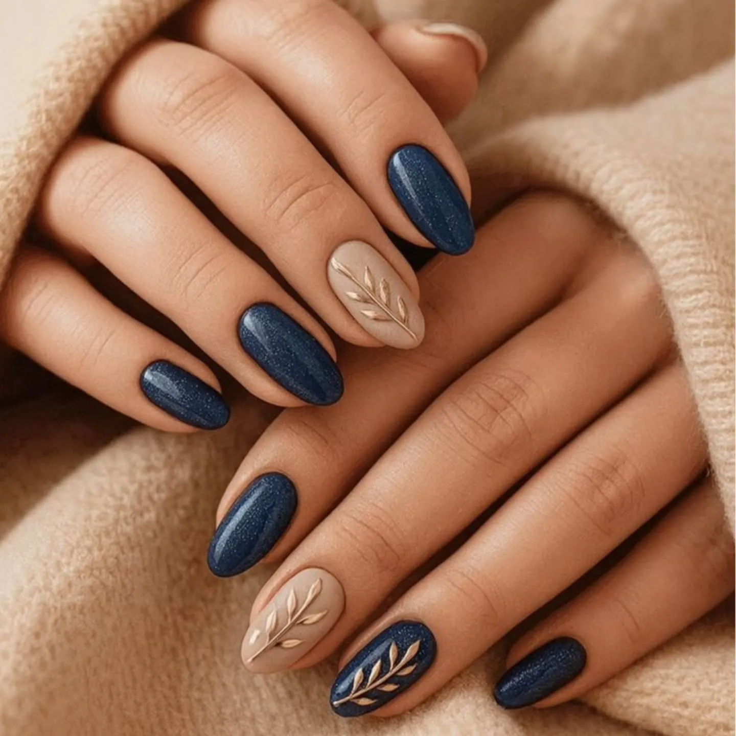 Blue shimmering almond nails with beige accents and fine leaf motifs