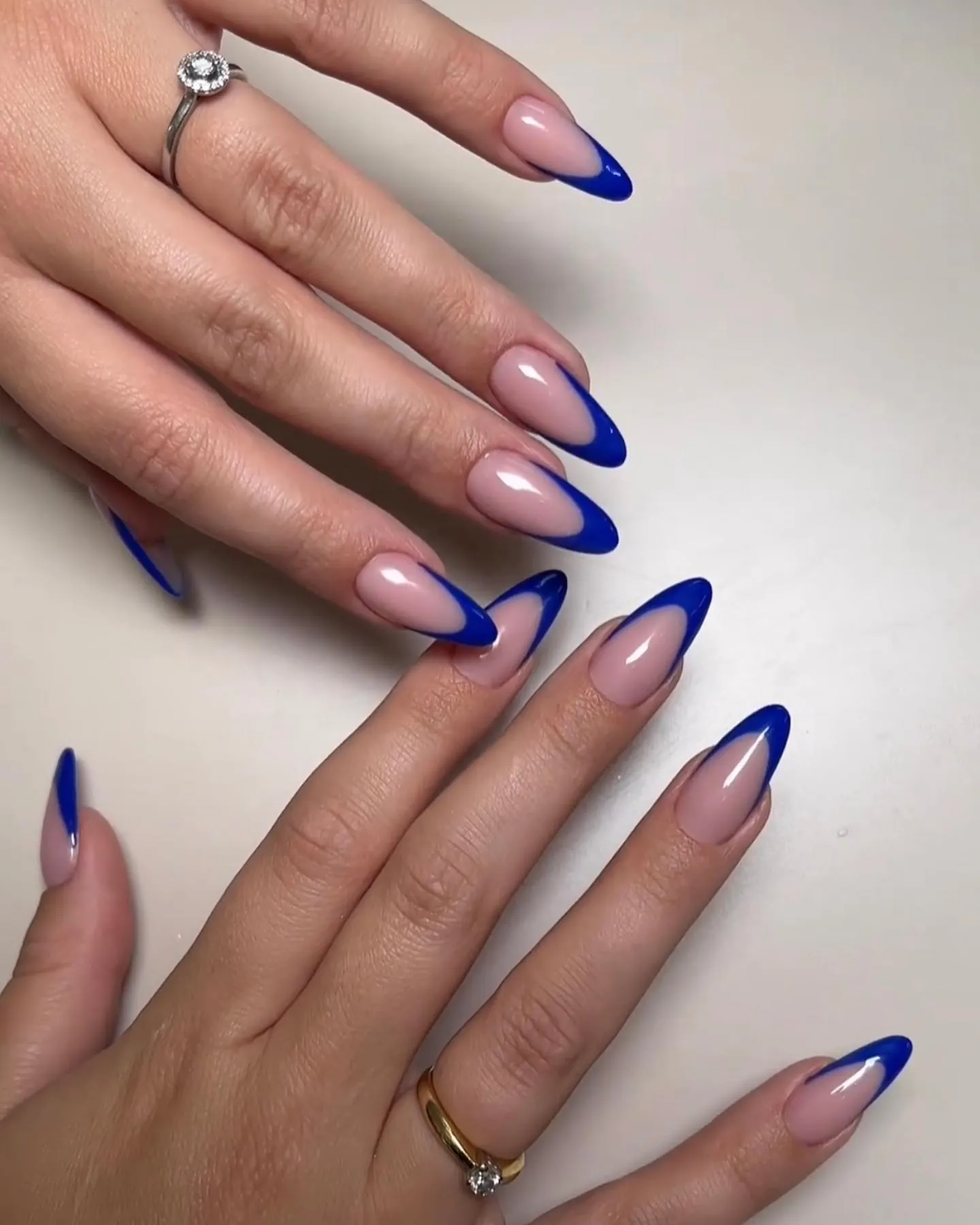 Pink almond nails with vivid blue curved French tips