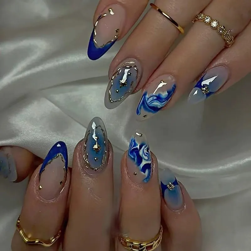 Almond nails with blue marbling, navy French tips and gold framed accents