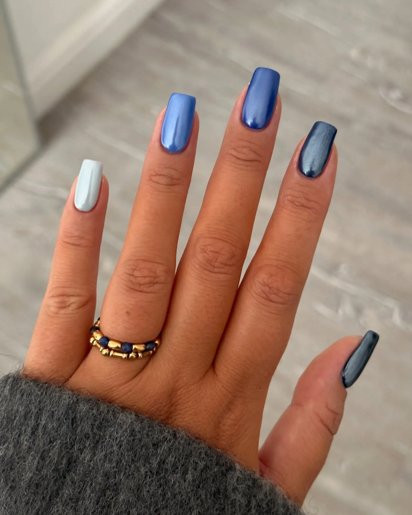 Blue ombre chrome nails with silver-blue highlights