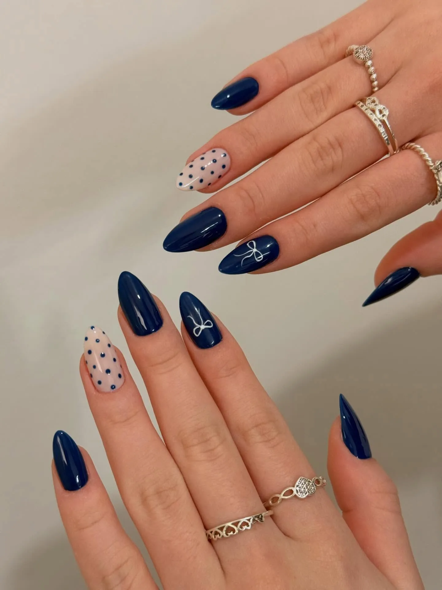 Pointed navy nails with speckled accent nails