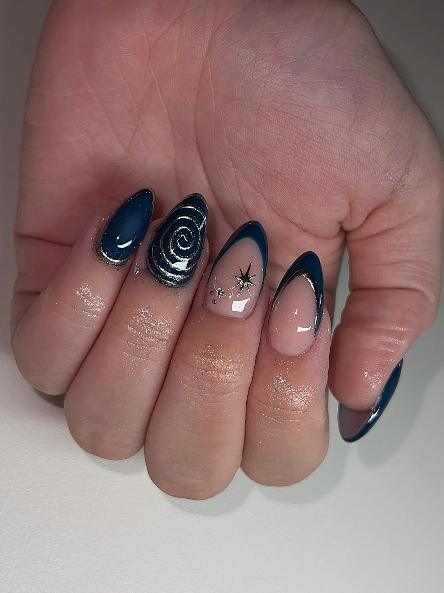 Navy almond nails with spiral and nude accents