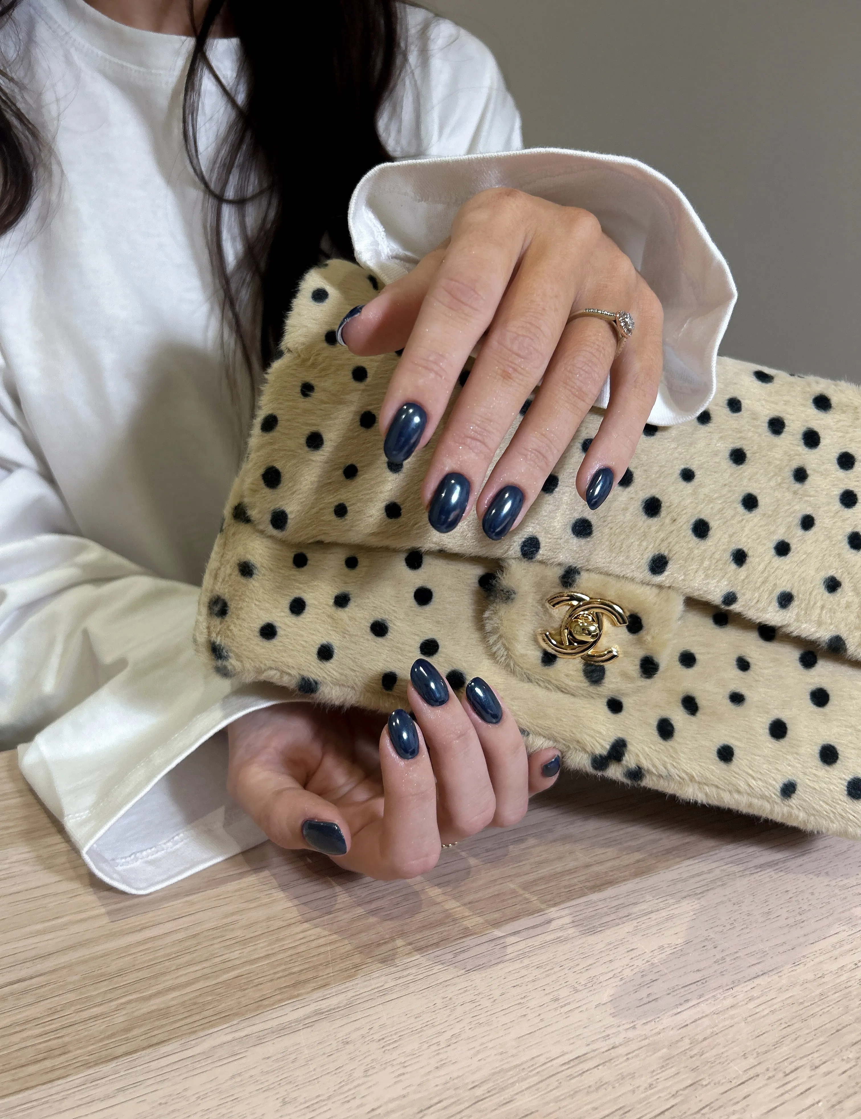 Navy blue dotted nail art on oval nails
