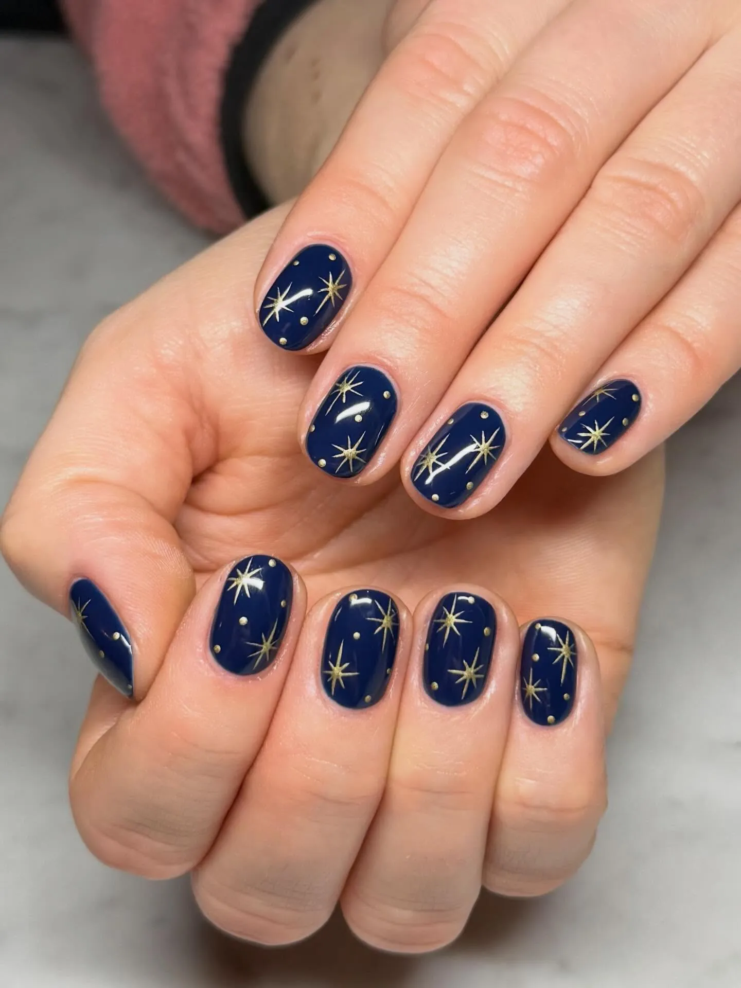 Navy nails with tiny gold flecks and accents