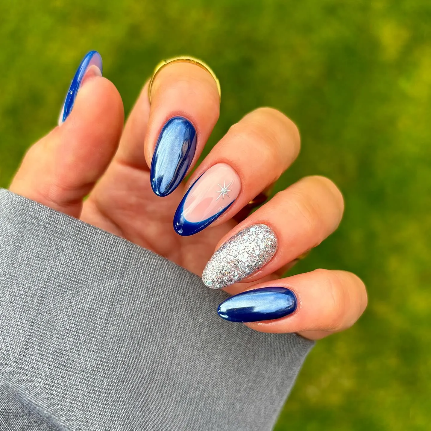 Blue curved French tip nails with silver sparkle accent