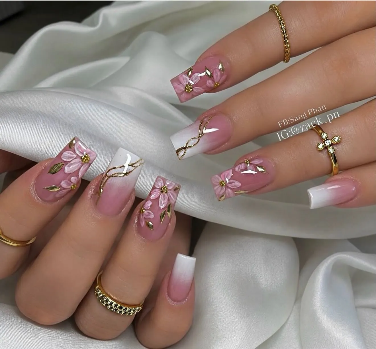 Long square pink and white French nails with raised flowers and gold lines