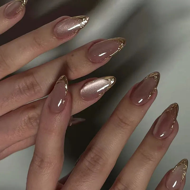 Muted pink almond nails with fine gold outlines and reflective accent nails