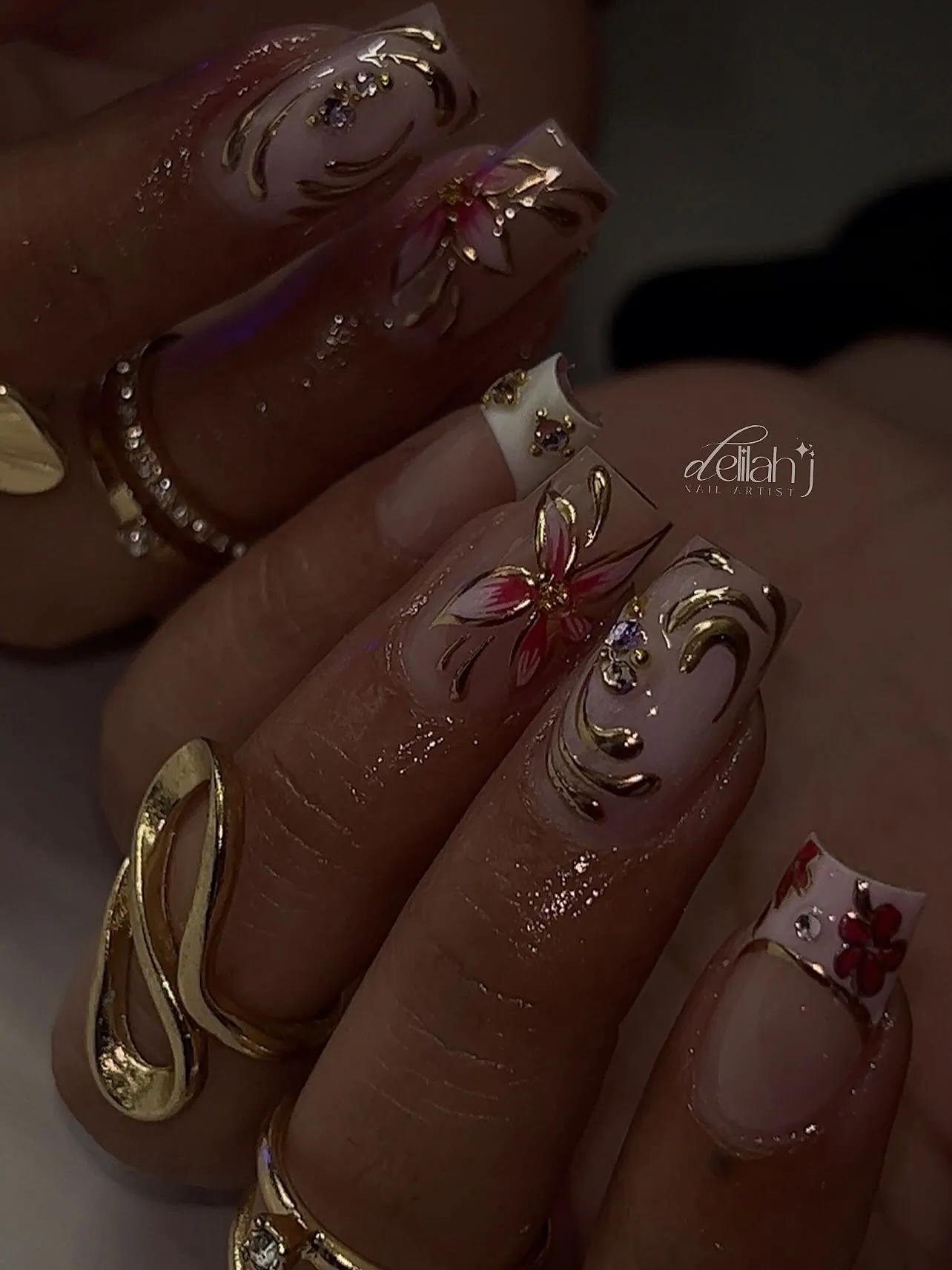 Pink nails with raised pink flowers, gold curved details and small gems