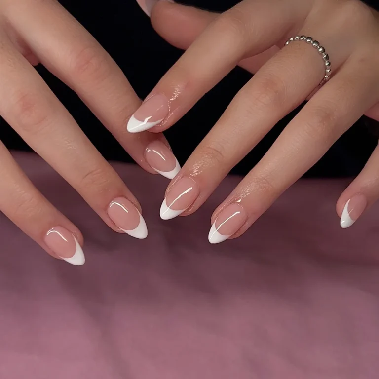 Soft pink almond nails with curved white French tips and a glossy finish.