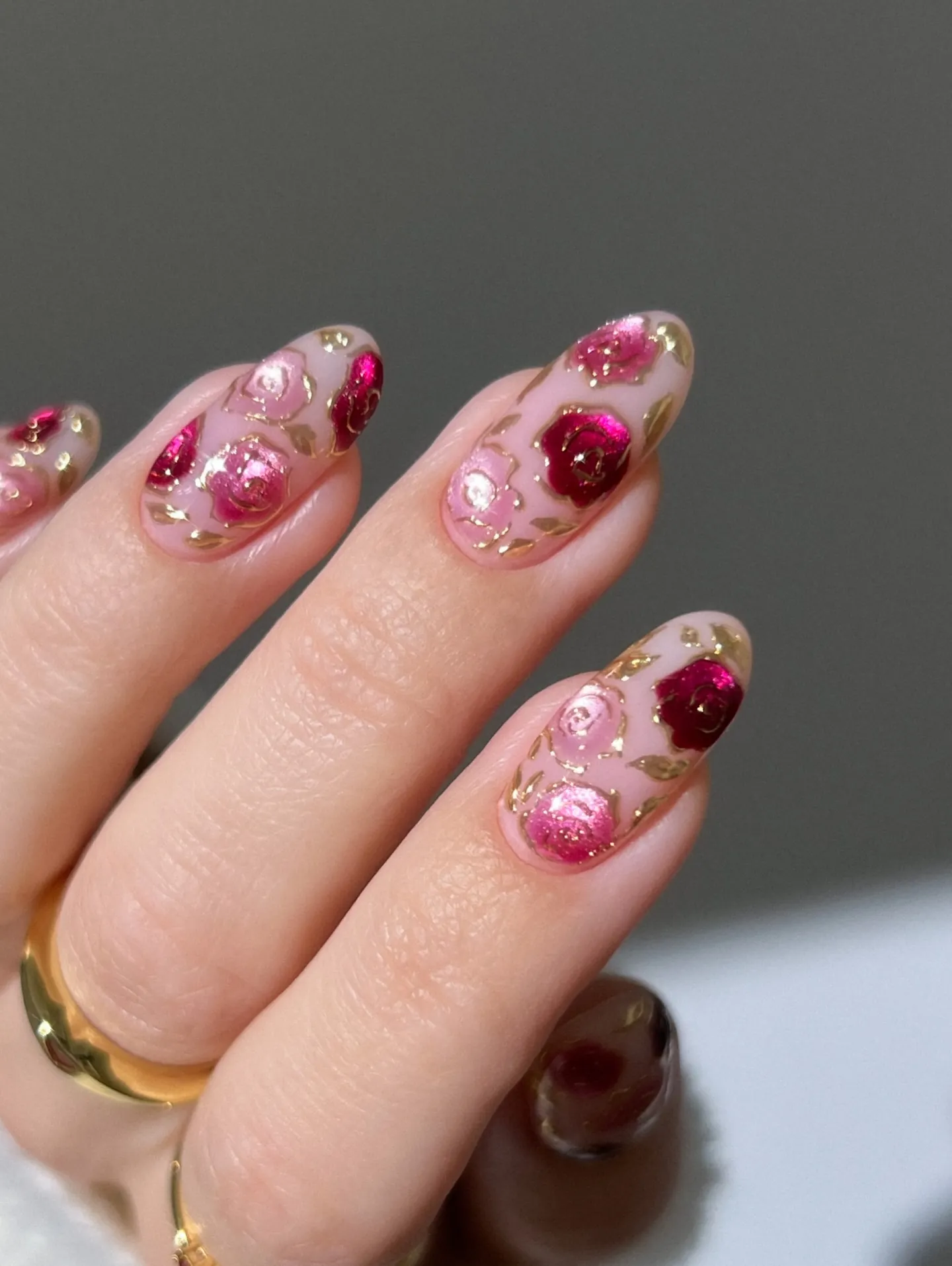 Pink almond nails with raised red and pink flowers and gold accents
