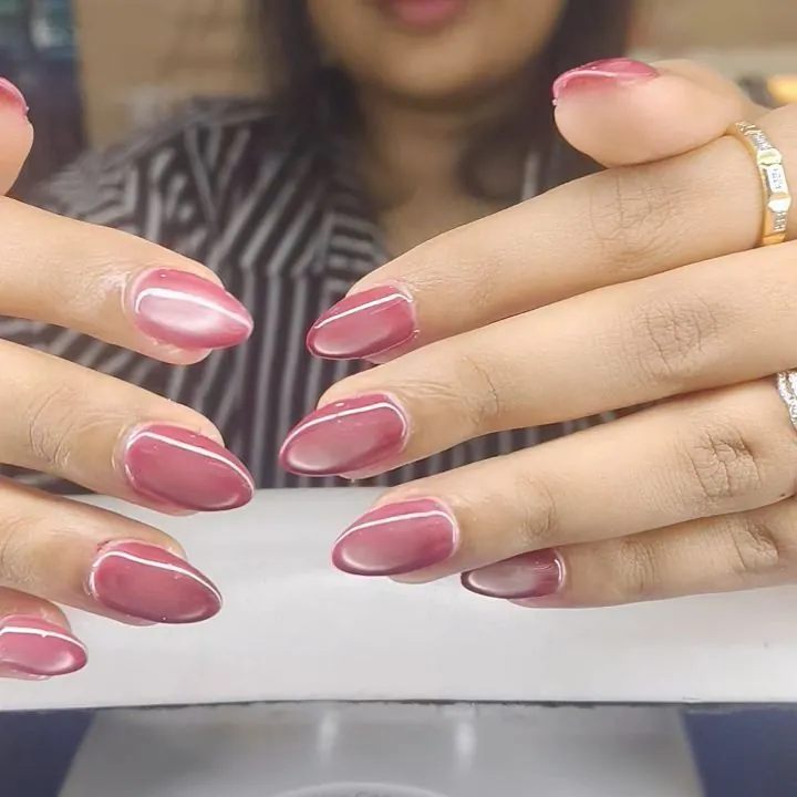 Pink almond nails edged with thin pale metallic borders