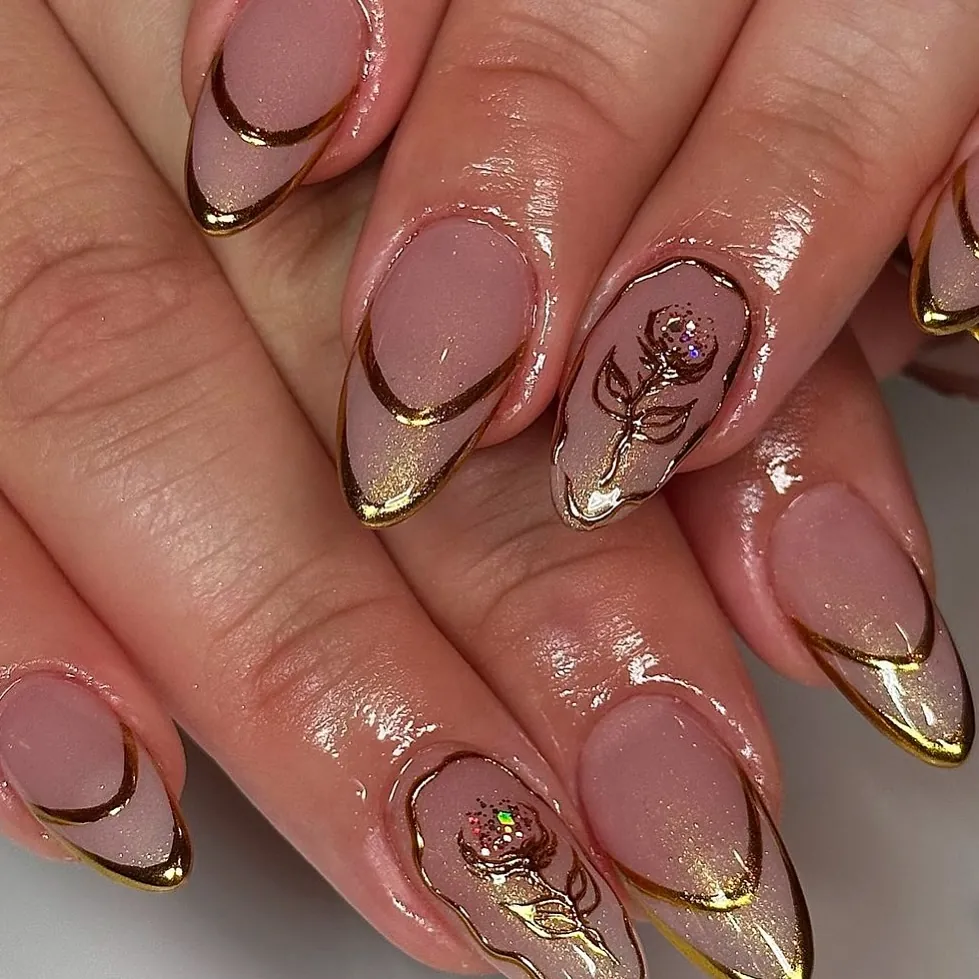Sheer pink almond nails with gold edged tips and rose artwork