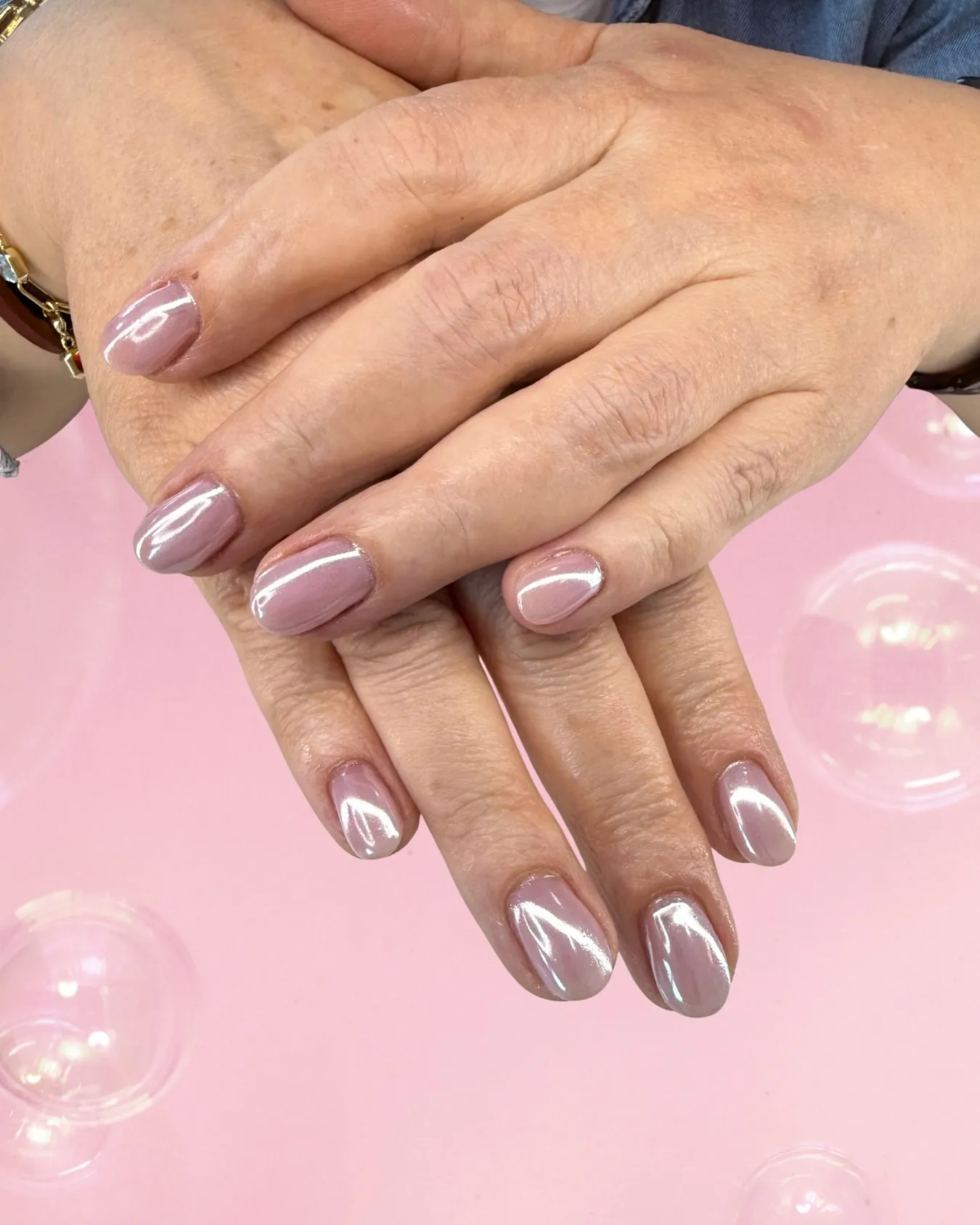 Short oval nails with a pale rose metallic finish