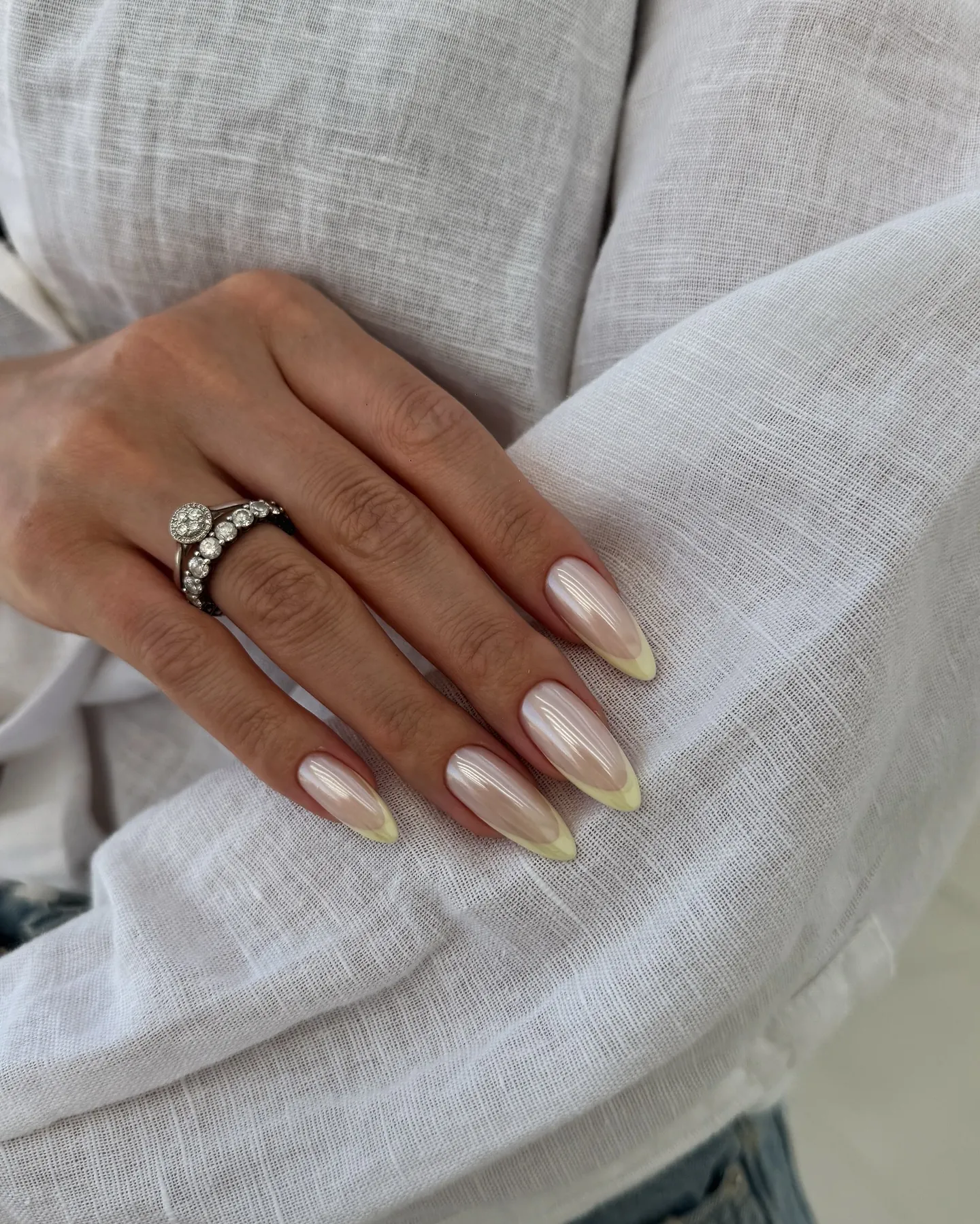 Almond nails with pearly pink bases and pale yellow French tips