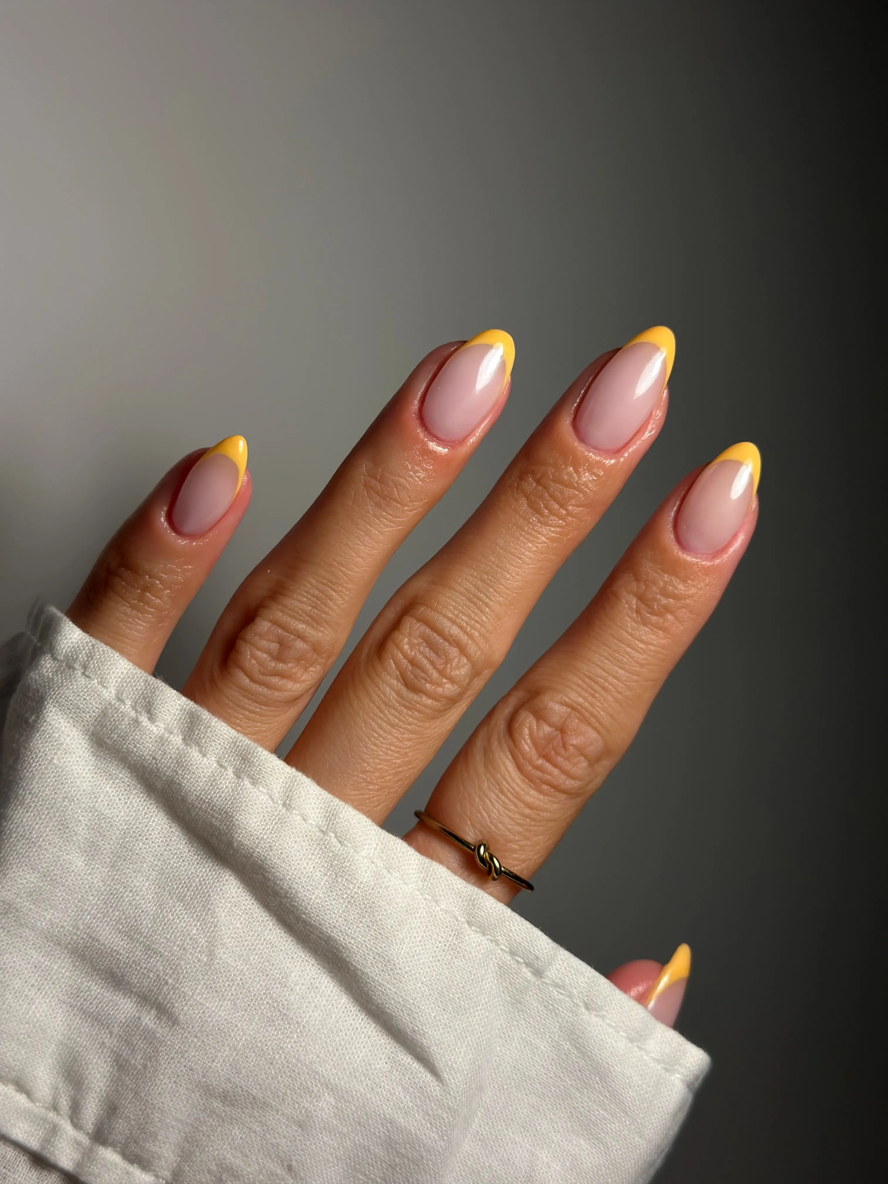 Pink almond nails with vivid yellow French tips