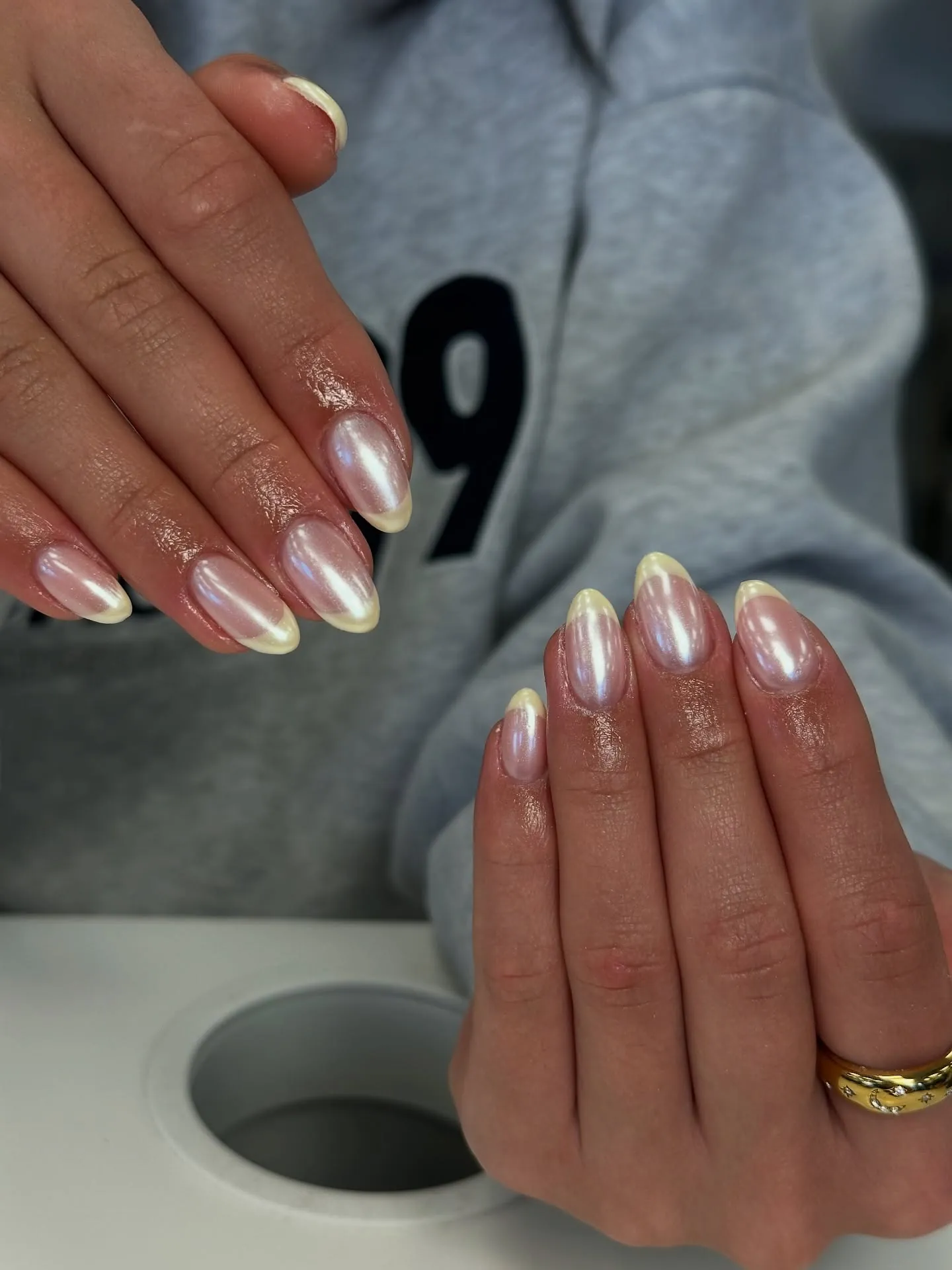 Short almond nails with silvery pearly bases and pale yellow tips