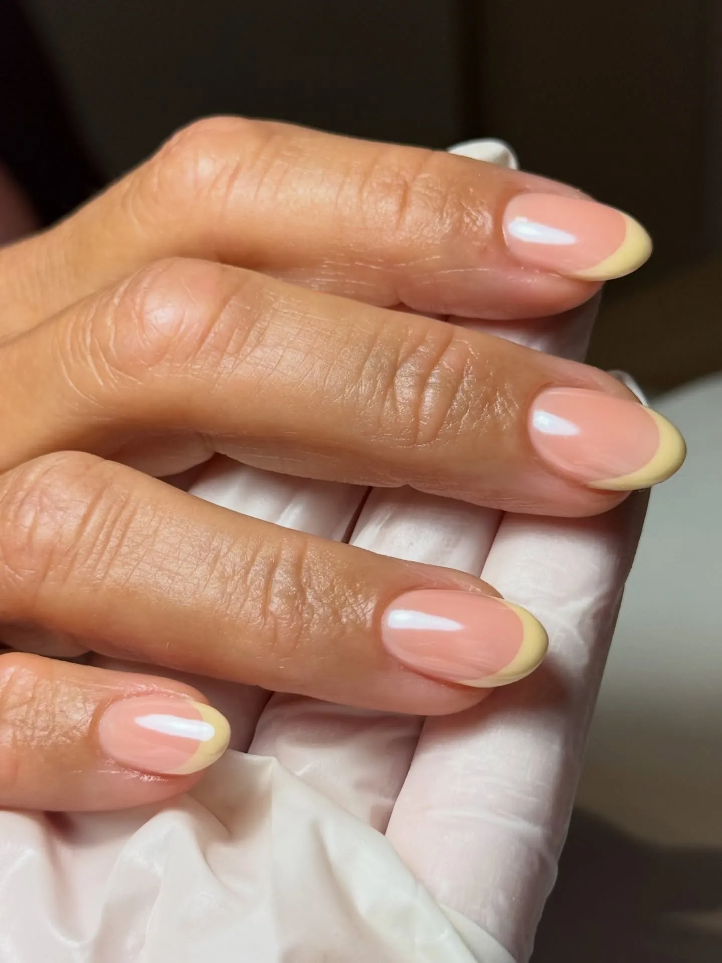 Rounded pink nails with slim pale yellow French tips