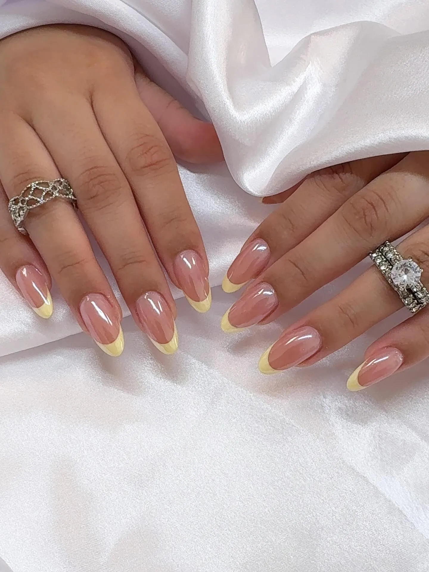 Sheer pink almond nails with pale yellow French borders
