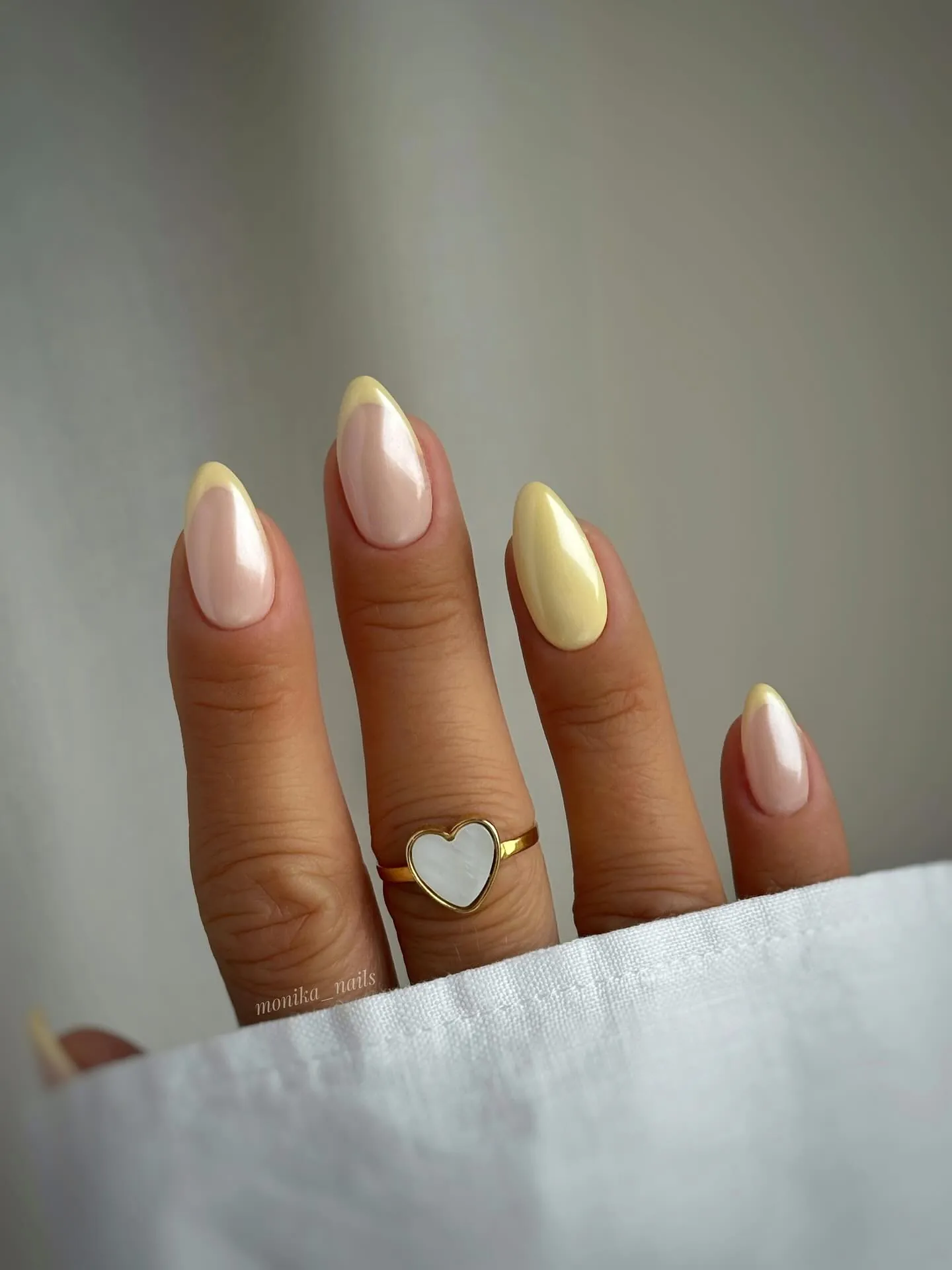 Pearly pink almond French nails with a solid pale yellow accent