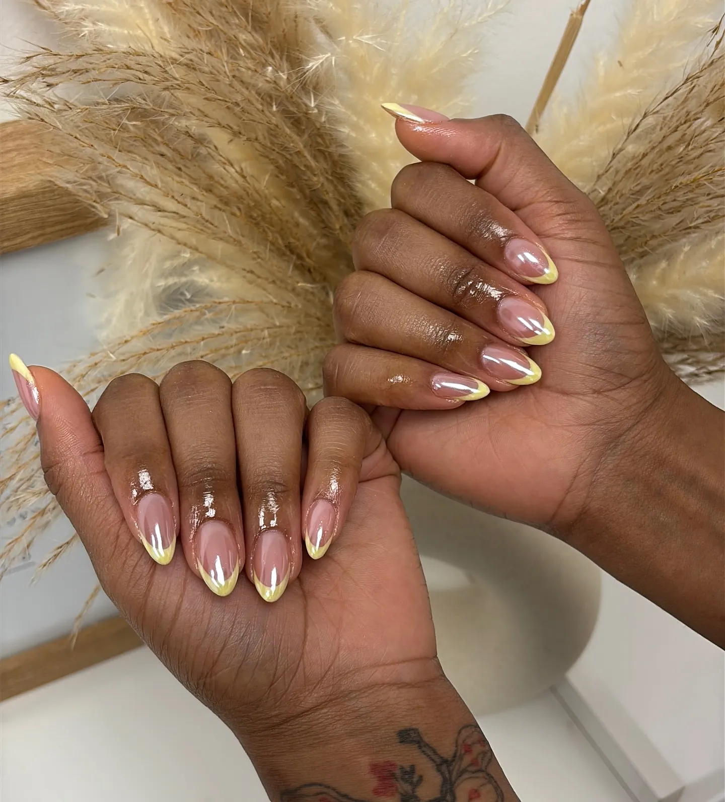 Pink almond nails with reflective yellow-gold French tips