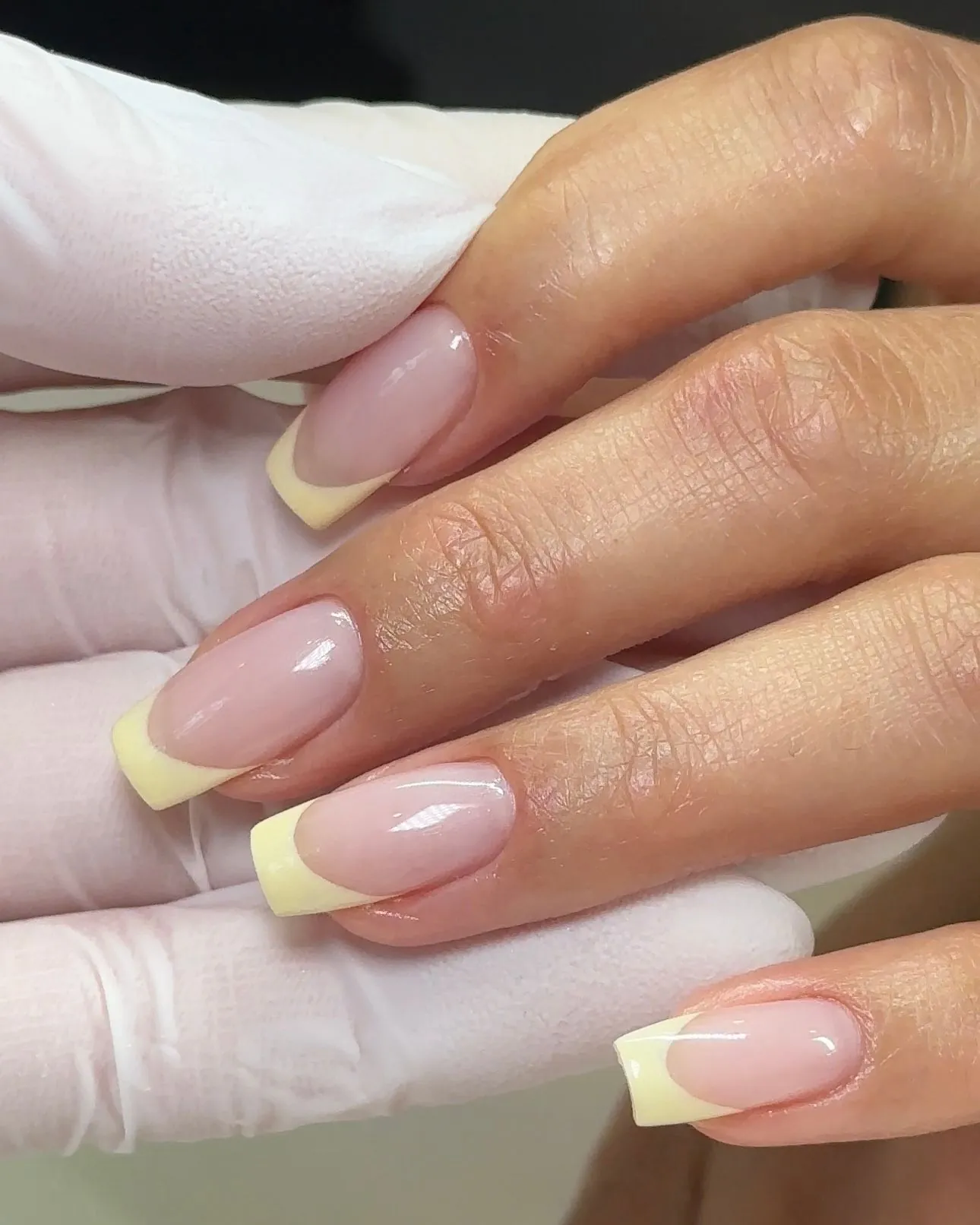 Long square pink nails with wide pale yellow French tips