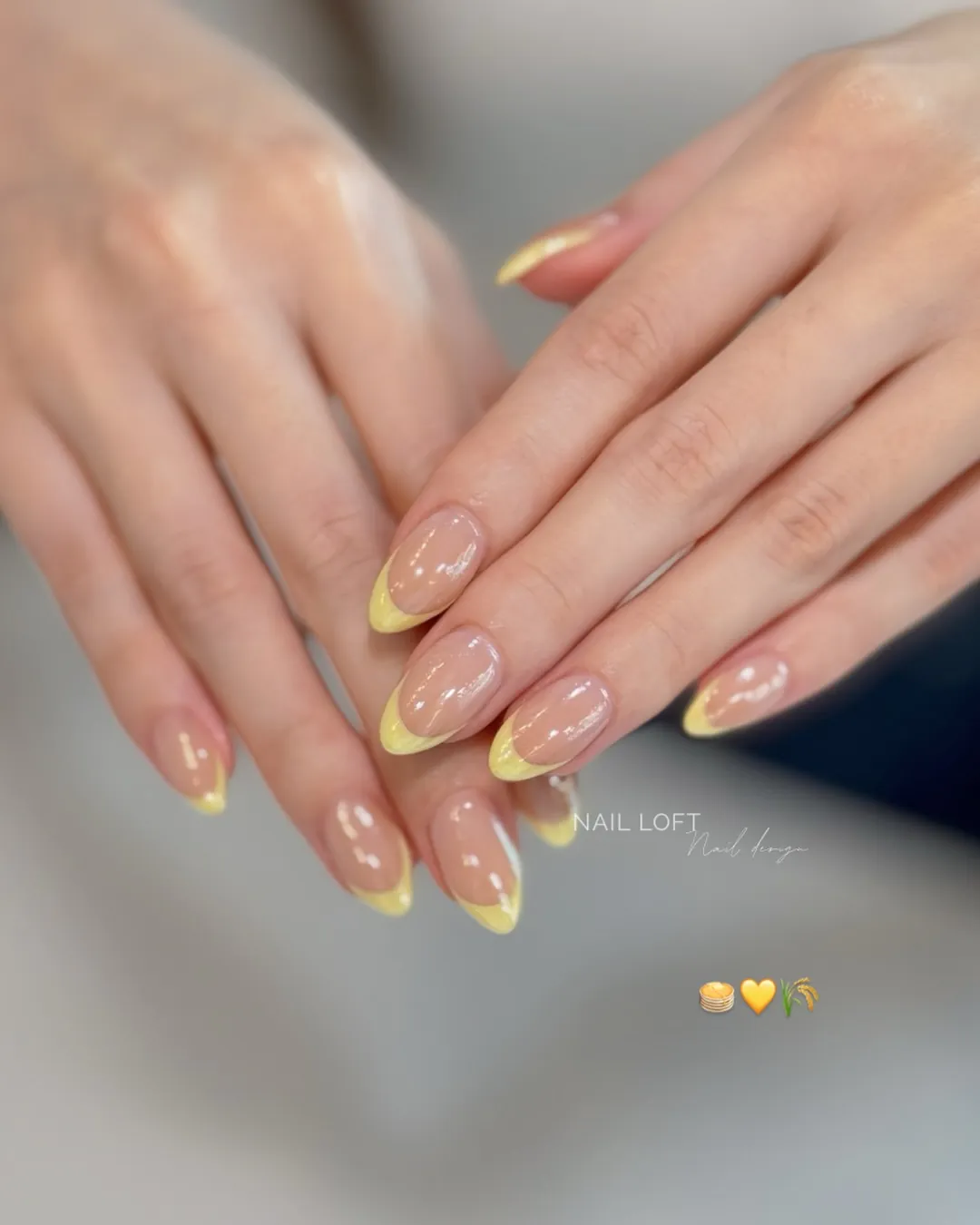 Glossy nude oval nails with softly translucent yellow French tips