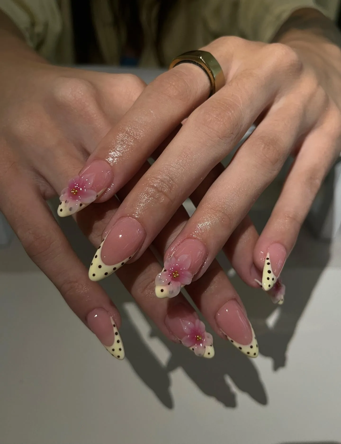 Pink almond nails with dotted pale yellow tips and raised pink flowers