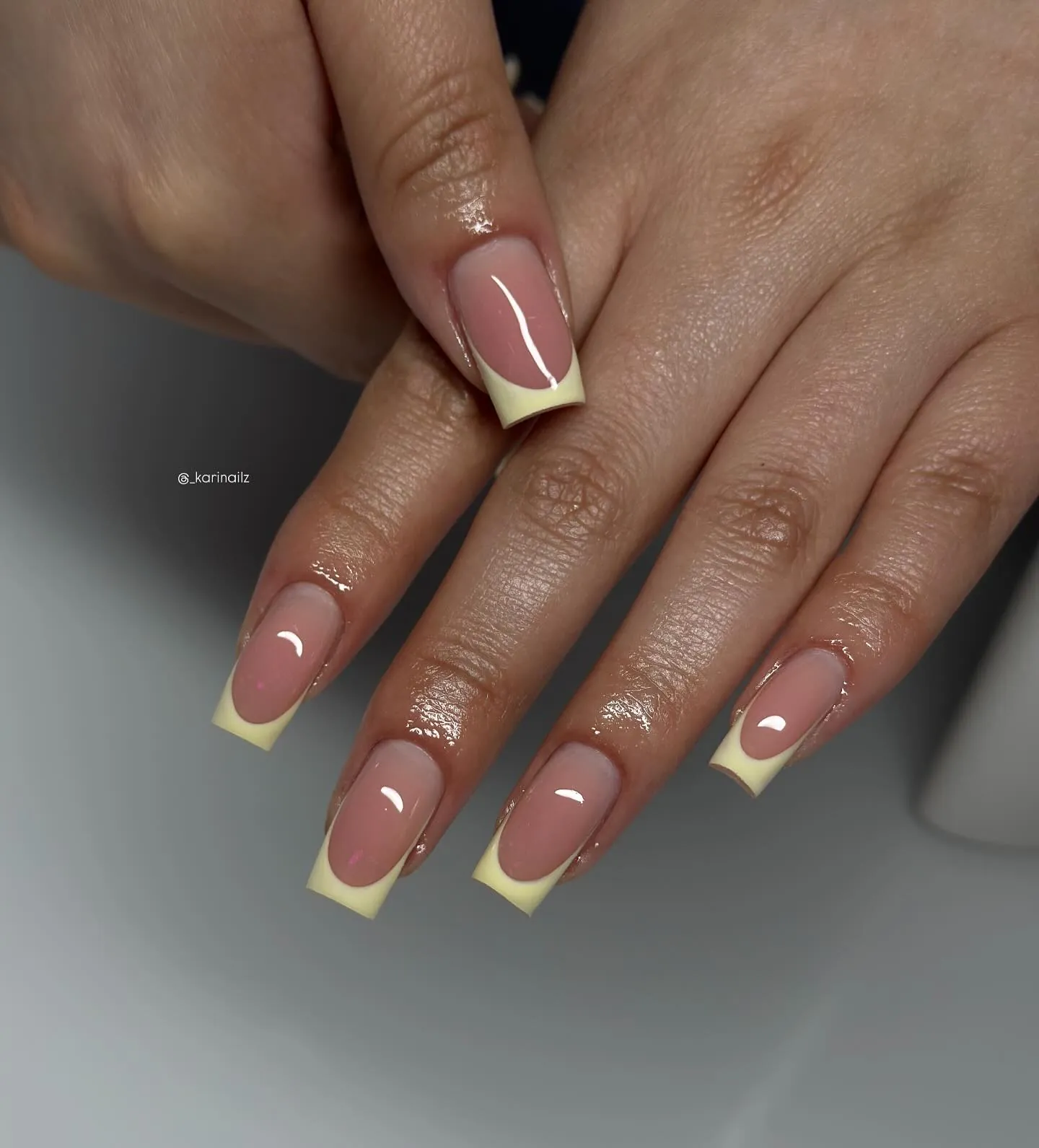 Square pink nails with pale yellow curved French tips