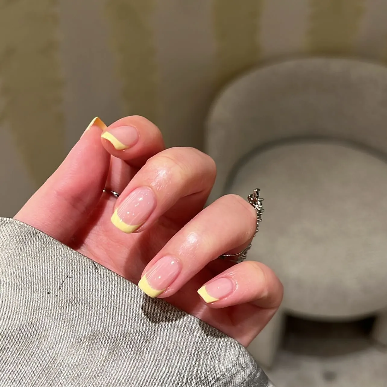Short rounded pink nails with broad yellow French tips